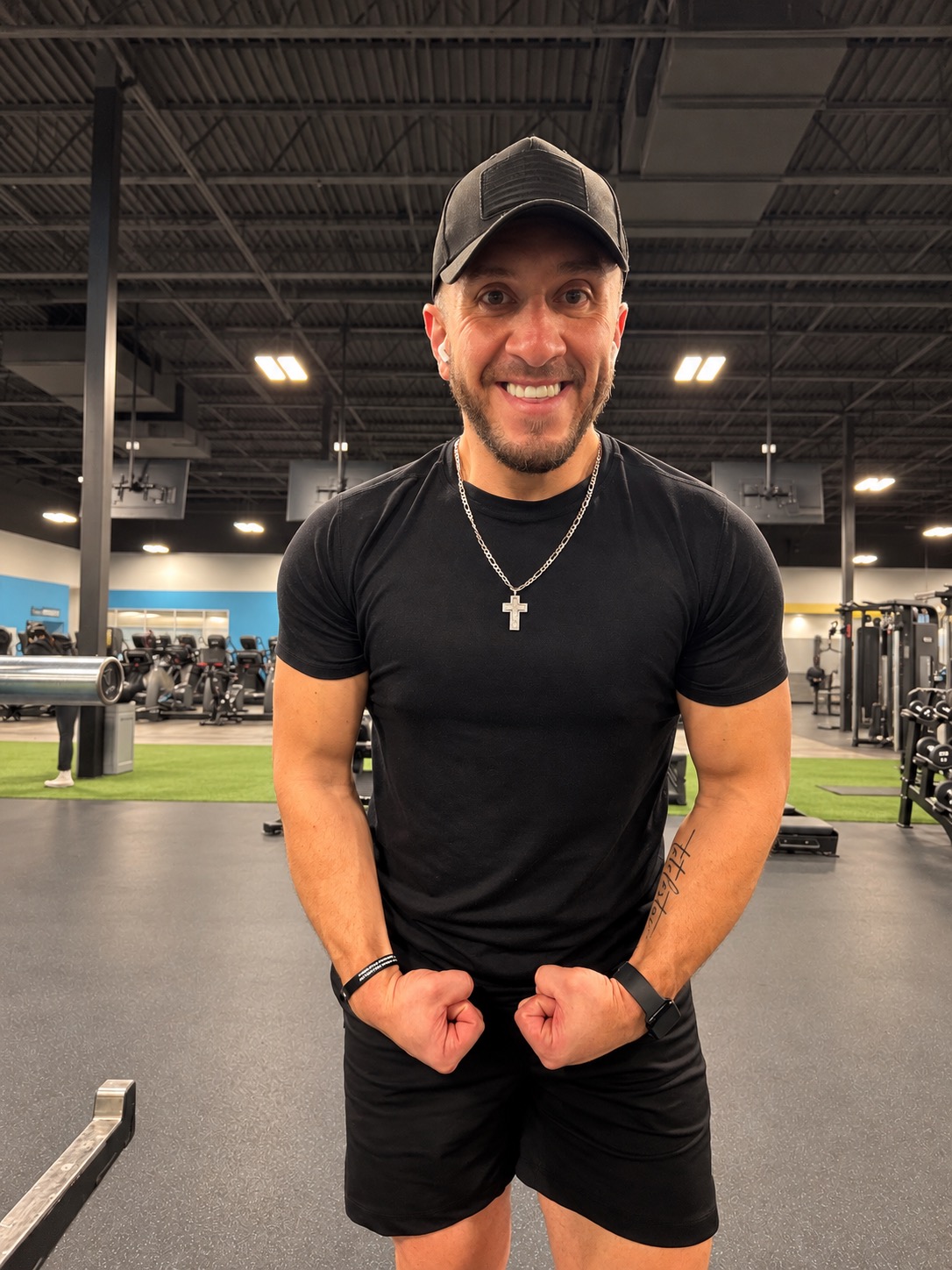 G smiling in a black shirt at the gym